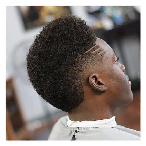 Black man with a burst fade variation of the low taper fade haircut on a white background.