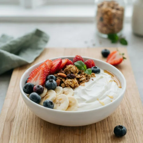 A healthy Day 3 breakfast featuring Greek yogurt, granola, fresh berries, and honey arranged on a clean white background.